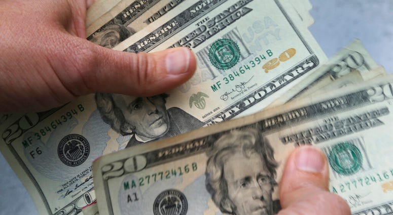 FILE - In this June 15, 2018, file photo, 20-dollar bills are counted in North Andover, Mass.