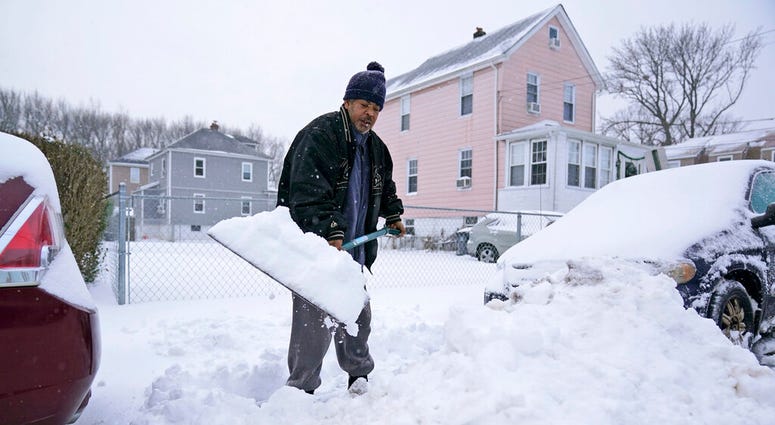 Barry James digs out his car, as well as his daughter's car, before trying to get to work in Englewood, N.J., Thursday, Dec. 17, 2020.