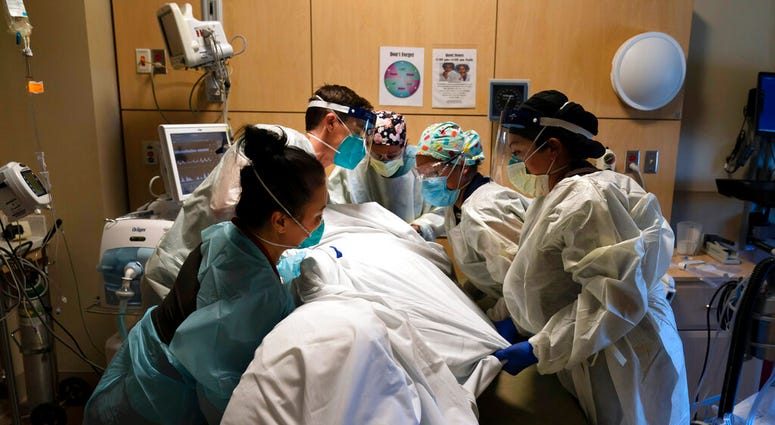 FILE - In this Nov. 19, 2020, file photo, medical personnel prone a COVID-19 patient at Providence Holy Cross Medical Center in the Mission Hills section of Los Angeles.