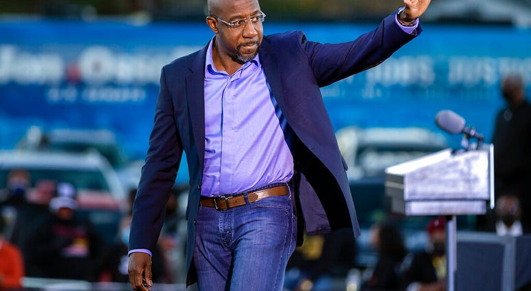 Democratic U.S. Senate candidate Rev. Raphael Warnock waves to supporters during a drive-in rally, Sunday, Jan. 3, 2021, in Savannah, Ga. (AP Photo/Stephen B. Morton) Democratic U.S. Senate candidate Rev. Raphael Warnock waves to supporters during a drive-in rally, Sunday, Jan. 3, 2021, in Savannah, Ga. (AP Photo/Stephen B. Morton)