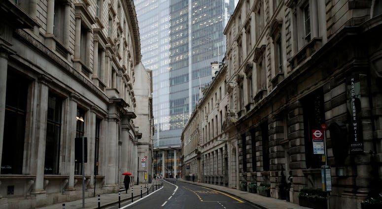 A person walks with an umbrella in light rain in the City of London financial district in London, Jan. 5, 2021, on the first morning of England entering a third national lockdown since the coronavirus outbreak began. (AP Photo/Matt Dunham) A person walks with an umbrella in light rain in the City of London financial district in London, Jan. 5, 2021, on the first morning of England entering a third national lockdown since the coronavirus outbreak began. (AP Photo/Matt Dunham)