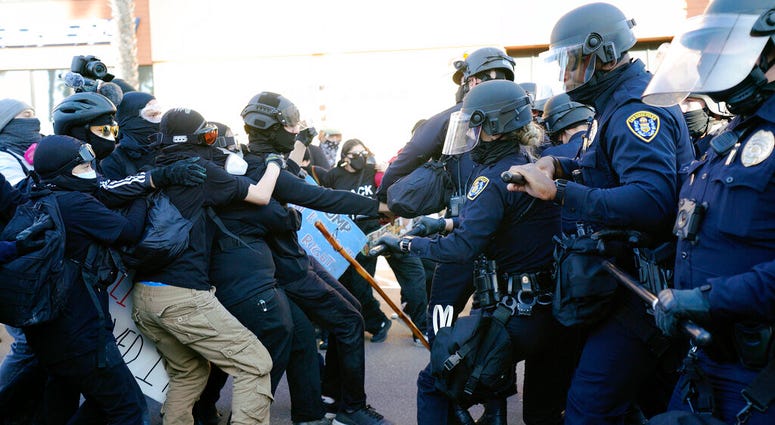 San Diego police clash with protesters after a gathering was declared an unlawful assembly, Saturday, Jan. 9, 2021, in San Diego.