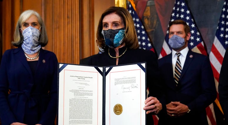 House Speaker Nancy Pelosi of Calif., displays the signed article of impeachment against President Donald Trump in an engrossment ceremony before transmission to the Senate for trial on Capitol Hill, in Washington. (AP Photo/Alex Brandon) House Speaker Nancy Pelosi of Calif., displays the signed article of impeachment against President Donald Trump in an engrossment ceremony before transmission to the Senate for trial on Capitol Hill, in Washington. (AP Photo/Alex Brandon)
