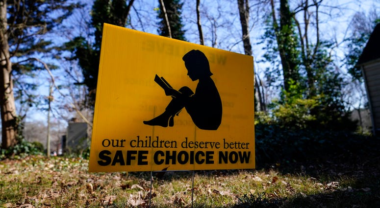 A sign that reads "our children deserve better safe choice now" is seen on Friday, Jan. 15, 2021, in Decatur, Ga. (AP Photo/Brynn Anderson) A sign that reads "our children deserve better safe choice now" is seen on Friday, Jan. 15, 2021, in Decatur, Ga. (AP Photo/Brynn Anderson)