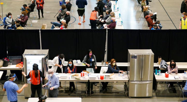 In this Jan. 24, 2021, file photo, people work near refrigerators used to store the Pfizer vaccine for COVID-19, as patients who have received the shot sit in an observation area. (AP Photo/Ted S. Warren) In this Jan. 24, 2021, file photo, people work near refrigerators used to store the Pfizer vaccine for COVID-19, as patients who have received the shot sit in an observation area. (AP Photo/Ted S. Warren)