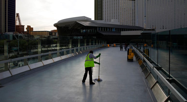 FILE - In this March 31, 2020, file photo, a worker cleans along the Las Vegas Strip devoid of the usual crowds as casinos and other business are shuttered due to the coronavirus outbreak in Las Vegas. (AP Photo/John Locher, File) FILE - In this March 31, 2020, file photo, a worker cleans along the Las Vegas Strip devoid of the usual crowds as casinos and other business are shuttered due to the coronavirus outbreak in Las Vegas. (AP Photo/John Locher, File)