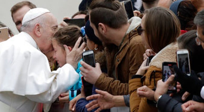 Pope Francis kisses a child in St. Peter's Square at the Vatican before leaving after his weekly general audience, Wednesday, Feb. 26, 2020. (AP Photo/Alessandra Tarantino) Pope Francis kisses a child in St. Peter's Square at the Vatican before leaving after his weekly general audience, Wednesday, Feb. 26, 2020. (AP Photo/Alessandra Tarantino)