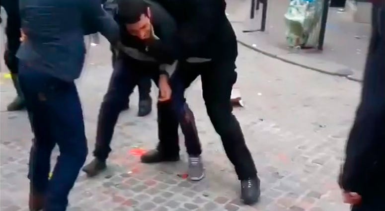 In this image taken from video, a man identified as Alexandre Benalla, right, a security chief to French President Emmanuel Macron, confronting a student during a May Day demonstration in Paris, May 1, 2018. The video came to light Thursday July 19, 2018,