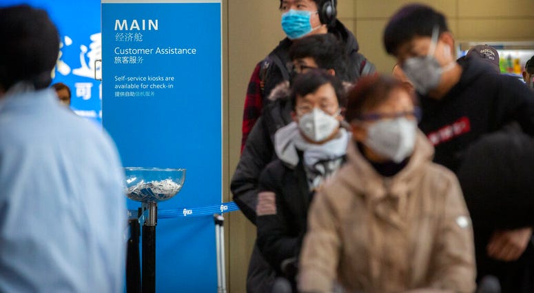 Travelers wearing face masks line up to check in for an American Airlines flight to Los Angeles at Beijing Capital International Airport in Beijing, Thursday, Jan. 30, 2020. (AP Photo/Mark Schiefelbein) Travelers wearing face masks line up to check in for an American Airlines flight to Los Angeles at Beijing Capital International Airport in Beijing, Thursday, Jan. 30, 2020. (AP Photo/Mark Schiefelbein)