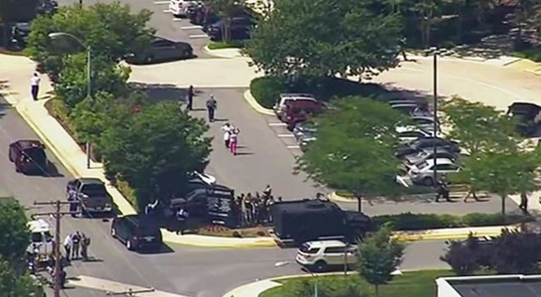 In this frame from video, people leave the Capital Gazette newspaper after multiple people have been shot on Thursday, June 28, 2018, in Annapolis, Md. (WJLA via AP)