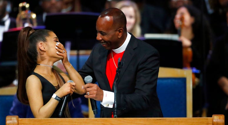 Ariana Grande, left, laughs with Bishop Charles H. Ellis during the funeral service for Aretha Franklin at Greater Grace Temple, Friday, Aug. 31, 2018, in Detroit. Franklin died Aug. 16, 2018 of pancreatic cancer at the age of 76. (AP Photo/Paul Sancya)