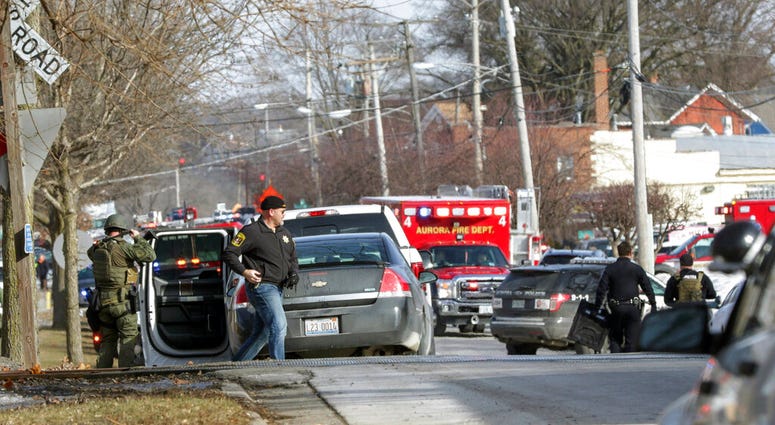 Law enforcement personnel gather near the scene of a shooting at an industrial park in Aurora, Ill., on Friday, Feb. 15, 2019. (Bev Horne/Daily Herald via AP)