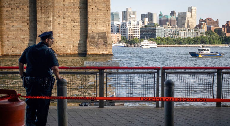A New York Police Department officer stands guard as authorities investigate the death of a baby boy who was found floating in the water near the Brooklyn Bridge in Manhattan, on Sunday, Aug. 5, 2018, in New York. No parent or guardian was present at the