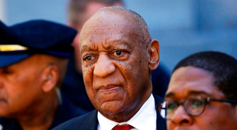 FILe - In this April 26, 2018 file photo, Bill Cosby, center, leaves the the Montgomery County Courthouse in Norristown, Pa. A representative from the Sexual Offenders Assessment Board has issued an assessment recommending that Bill Cosby be classified as