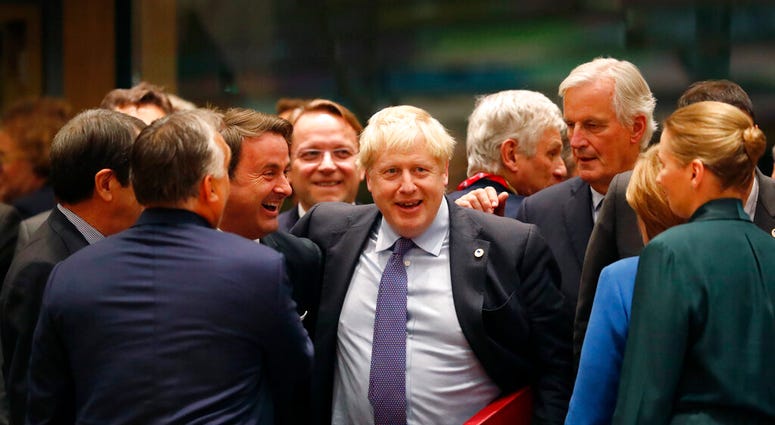 British Prime Minister Boris Johnson, center, is greeted by Luxembourg's Prime Minister Xavier Bettel, center left, during a round table meeting at an EU summit in Brussels, Thursday, Oct. 17, 2019. (AP Photo/Frank Augstein)