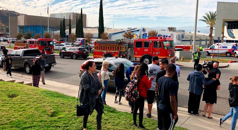 People wait for students and updates outside of Saugus High School after reports of a shooting on Thursday, Nov. 14, 2019, in Santa Clarita, Calif. (AP Photo/Marcio Jose Sanchez)