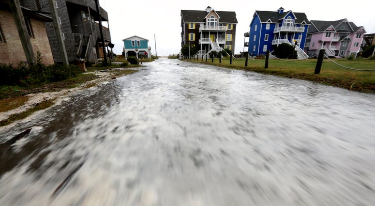 Ocean water rushes down Cape Hatteras Pier Drive in Frisco, N.C., on Hatteras Island as the effects of Hurricane Florence reach the area on Thursday, Sept. 13, 2018. (Steve Earley /The Virginian-Pilot via AP)