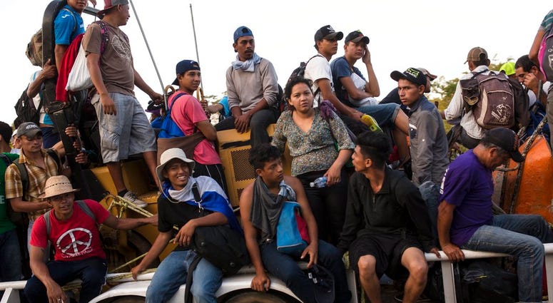 Central American migrants traveling with a caravan to the U.S. crowd onto a tractor as they make their way to Mapastepec, Mexico, Wednesday, Oct. 24, 2018. (AP Photo/Rodrigo Abd)