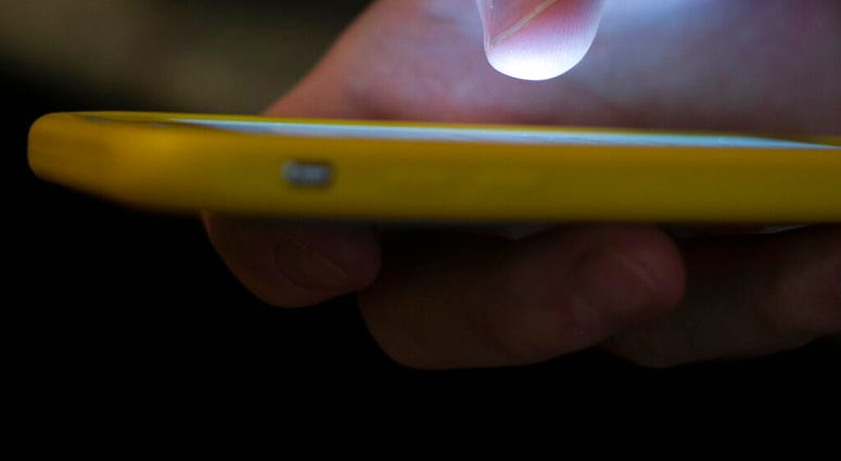 FILE - In this Aug. 11, 2019, file photo, a man uses a cell phone. The Federal Communications Commission is setting up a new three-digit number to reach a suicide prevention hotline. (AP Photo/Jenny Kane, File) FILE - In this Aug. 11, 2019, file photo, a man uses a cell phone. The Federal Communications Commission is setting up a new three-digit number to reach a suicide prevention hotline. (AP Photo/Jenny Kane, File)