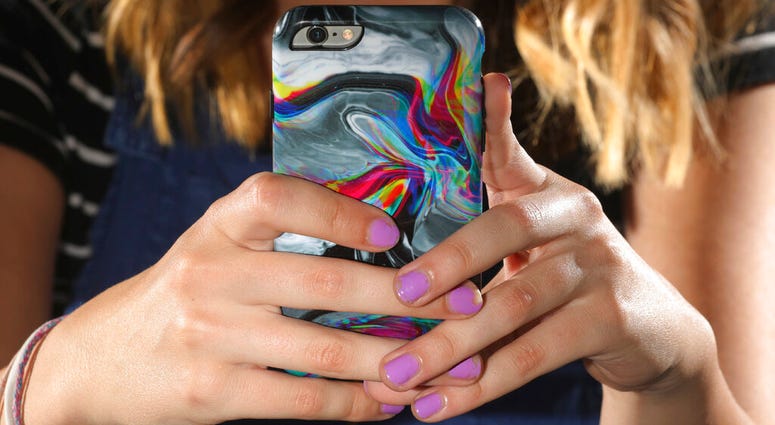 In this Monday, July 22, 2019, photo, Rachel Whalen looks at her phone at her home. (AP Photo/Rick Bowmer)