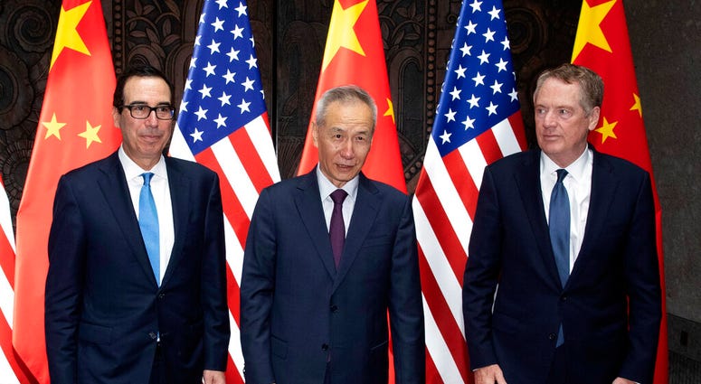 Chinese Vice Premier Liu He, center, poses with U.S. Trade Representative Robert Lighthizer, right, and Treasury Secretary Steven Mnuchin, for photos before holding talks at the Xijiao Conference Center in Shanghai. (AP Photo/Ng Han Guan, Pool)