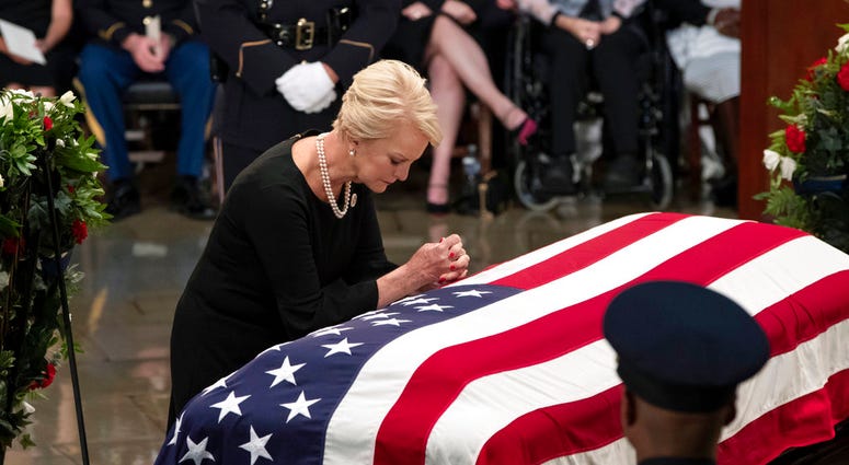 Cindy McCain, wife of Sen. John McCain, R-Ariz., leans over his flag-draped casket in the U.S. Capitol rotunda during a farewell ceremony, Friday, Aug. 31, 2018, in Washington. The six-term Republican senator, who lived and worked in the nation's capital