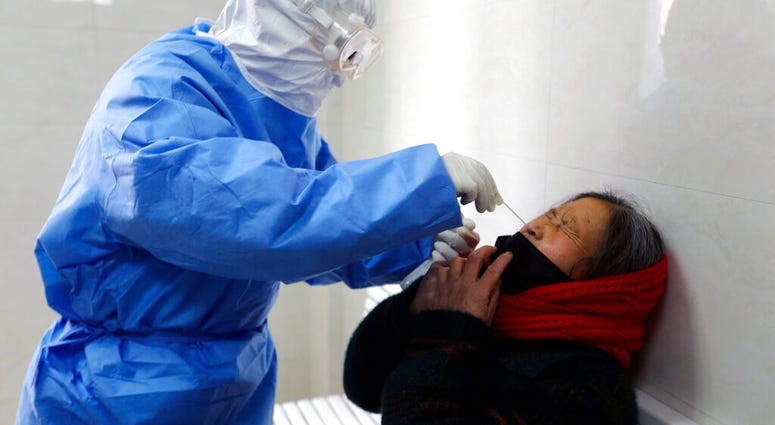 A doctor takes a swab from a woman to test for the COVID-19 virus at a fever clinic in Yinan county in eastern China's Shandong province on Wednesday, Feb. 12, 2020. (Chinatopix Via AP) A doctor takes a swab from a woman to test for the COVID-19 virus at a fever clinic in Yinan county in eastern China's Shandong province on Wednesday, Feb. 12, 2020. (Chinatopix Via AP)