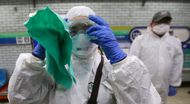 A worker wearing protective gears adjusts her glasses while she prepares to spray disinfectant as a precaution against the coronavirus at a subway station in Seoul, South Korea, Friday, Feb. 21, 2020. (AP Photo/Ahn Young-joon) A worker wearing protective gears adjusts her glasses while she prepares to spray disinfectant as a precaution against the coronavirus at a subway station in Seoul, South Korea, Friday, Feb. 21, 2020. (AP Photo/Ahn Young-joon)