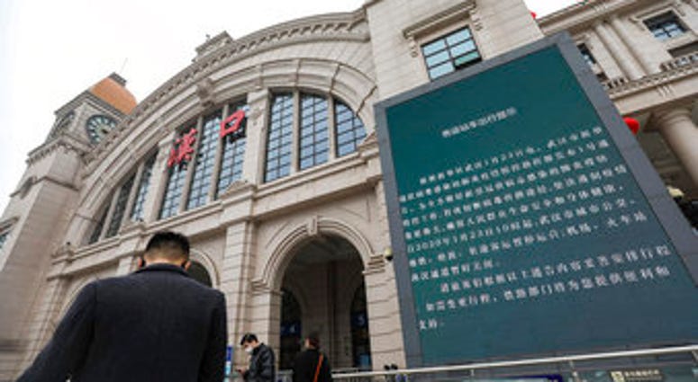 People walk past a billboard announcing the closure of the Hankou Railway Station in Wuhan in central China's Hubei Province, Thursday, Jan. 23, 2020. (Chinatopix via AP) People walk past a billboard announcing the closure of the Hankou Railway Station in Wuhan in central China's Hubei Province, Thursday, Jan. 23, 2020. (Chinatopix via AP)
