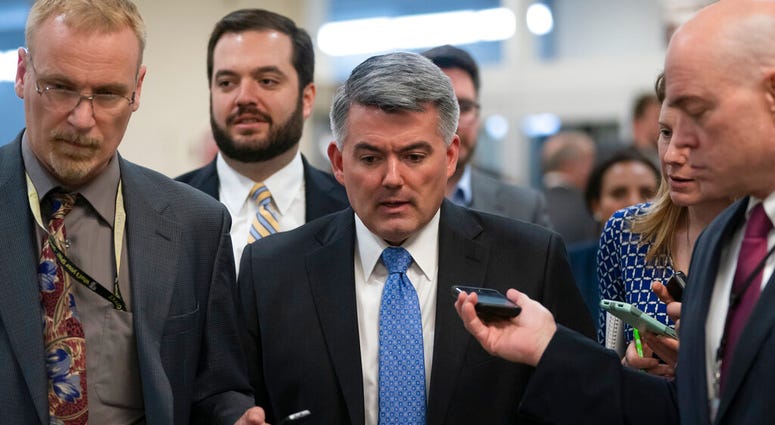 FILE - In this March 13, 2019 file photo, reporters pose questions to Sen. Cory Gardner, R-Colo., on his way to a vote at the Capitol in Washington. (AP Photo/J. Scott Applewhite)