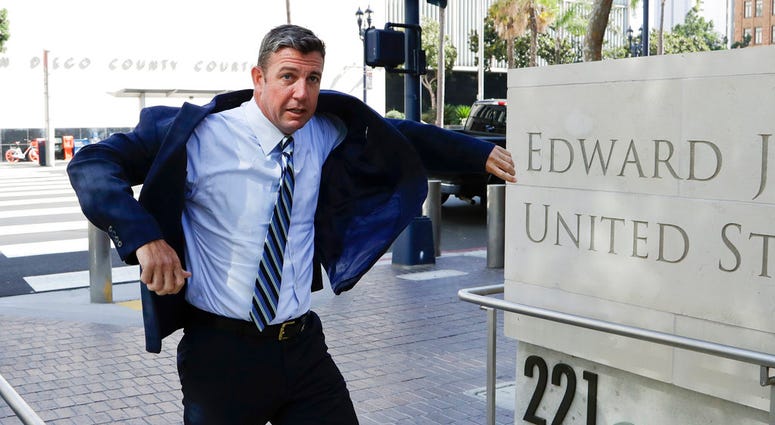 In this Aug. 23, 2018 photo, Rep. Duncan Hunter, R-Calif., pulls on his coat as he arrives for an arraignment hearing in San Diego. Winning re-election while indicted is a rare feat in U.S. history. (AP Photo/Gregory Bull)