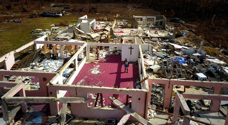 Pastor Jeremiah Saunders poses for a photo among the ruins of his church that was destroyed by Hurricane Dorian, in High Rock, Grand Bahama, Bahamas, Wednesday Sept. 11, 2019. (AP Photo / Ramon Espinosa)