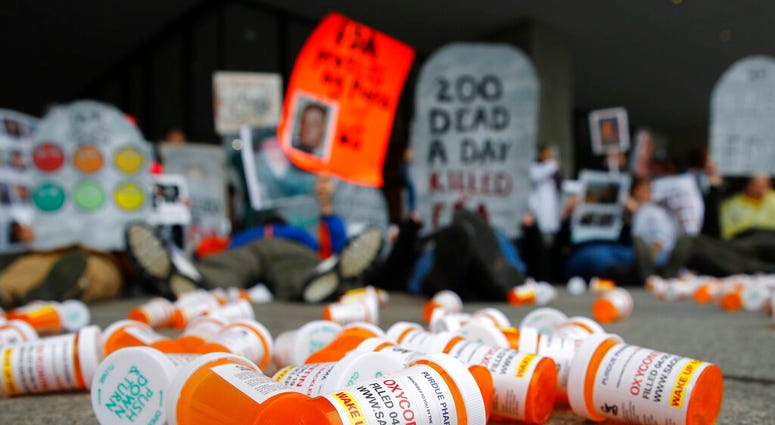 FILE - In this April 5, 2019, file photo, containers depicting OxyContin prescription pill bottles lie on the ground in front of the Department of Health and Human Services' headquarters in Washington. (AP Photo/Patrick Semansky, File)
