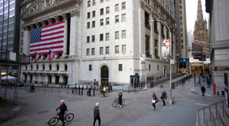 FILE- In this March 18, 2020, file photo a few people walk on Wall Street in front of the New York Stock Exchange in New York. (AP Photo/Mark Lennihan, File) FILE- In this March 18, 2020, file photo a few people walk on Wall Street in front of the New York Stock Exchange in New York. (AP Photo/Mark Lennihan, File)