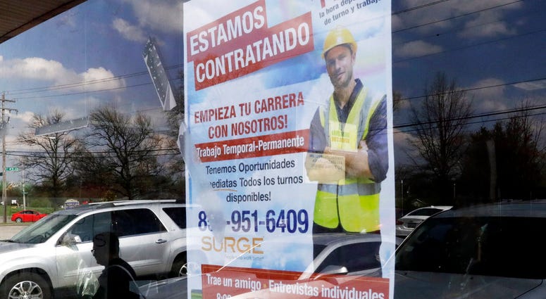 FILE - In this April 27, 2018 file photo, a poster announcing available jobs hangs in the window of the store La Guadalupana in Florence, Ky. One of President Donald Trump’s top priorities _ low unemployment _ is complicating another: curbing immigration.