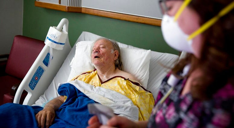 FILE - in this file photo, a flu patient is tended due by a nurse. As of January 2019, the current flu season is shaping up to be gentler than last winter’s unusually brutal one, health officials say. (AP Photo/David Goldman)