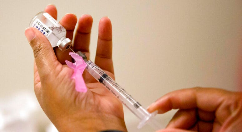 FILE - In this Feb. 7, 2018 file photo, a nurse prepares a flu shot. The flu forecast is cloudy and it’s too soon to know if the U.S. is in for a third miserable season in a row. (AP Photo/David Goldman, File)