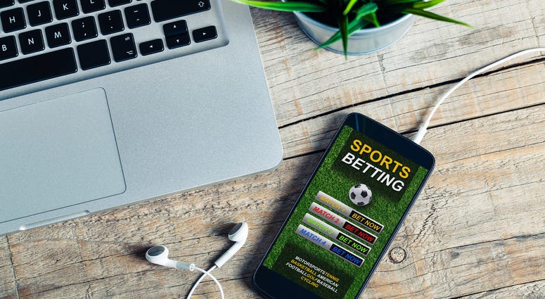Mobile phone at the office with sports betting website in the screen, placed at the office.