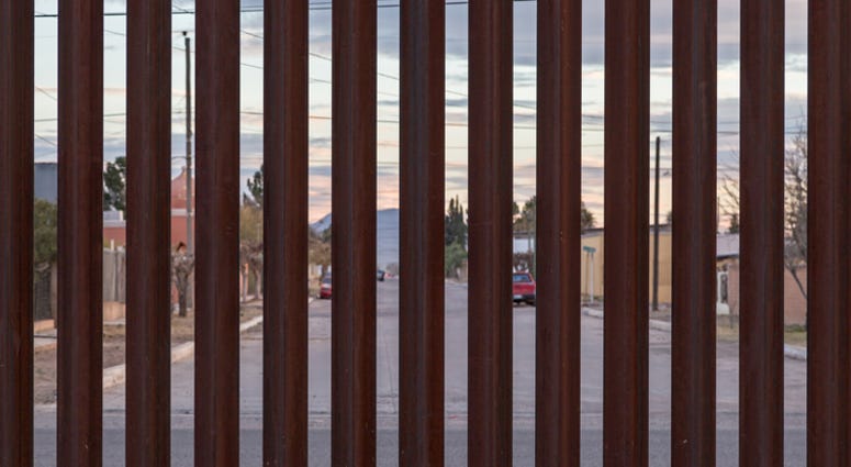 Looking at the border fence between the USA and Mexico, with a town in Mexico visible on the other side