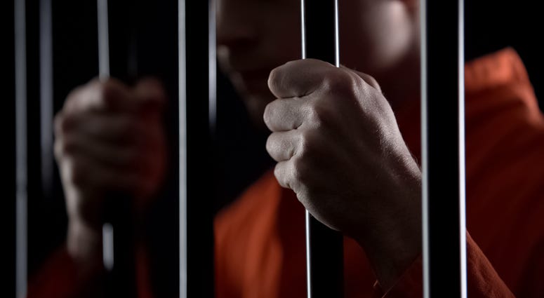 criminal holding jail bars feeling regret for committing crime closeup