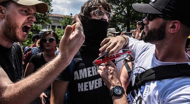 Left-wing protesters yell at Trump supporter