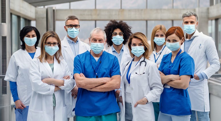 A group of doctors with face masks looking at camera,