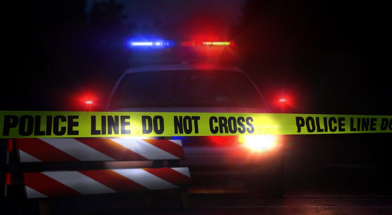 Police car at a crime scene at night with police yelloe tape line