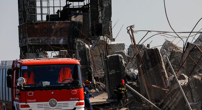 Firefighters search for trapped people at a damaged structure following an earthquake at the port of Piraeus, near Athens, on Friday, July 19, 2019. (AP Photo/Petros Giannakouris)
