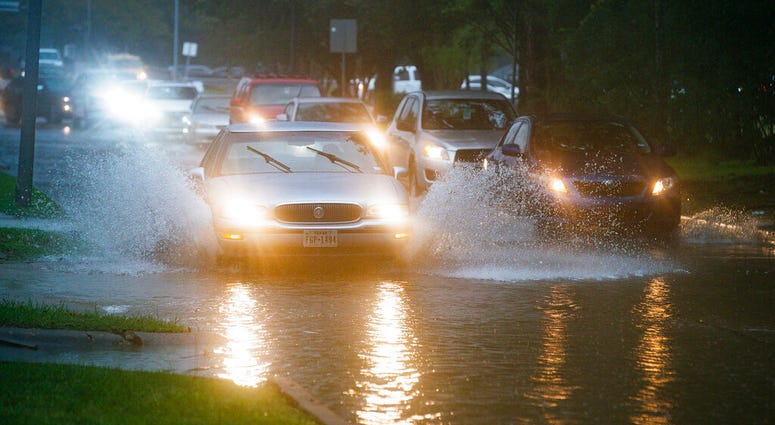 Vehicles splash through heavy water filling Chimney Rock, south of Brays Bayou in Houston, Tuesday, Sept. 17, 2019. (Mark Mulligan/Houston Chronicle via AP)