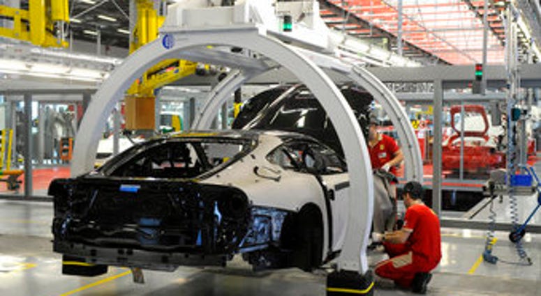 FILE - In this Wednesday, May 8, 2013 file photo, a technician works at the Ferrari department factory in Maranello, Italy. (AP Photo/Marco Vasini, File) FILE - In this Wednesday, May 8, 2013 file photo, a technician works at the Ferrari department factory in Maranello, Italy. (AP Photo/Marco Vasini, File)