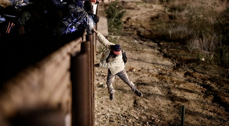 A migrant jumps the border fence to get into the U.S. side to San Diego, Calif., from Tijuana, Mexico, Tuesday, Jan. 1, 2019. (AP Photo/Daniel Ochoa de Olza)