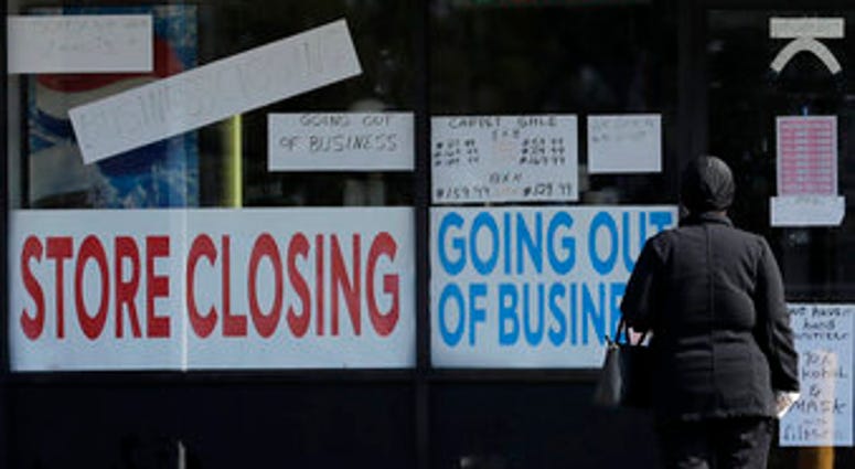 A woman looks at signs at a store closed due to COVID-19 in Niles, Ill., Wednesday, May 13, 2020. (AP Photo/Nam Y. Huh) A woman looks at signs at a store closed due to COVID-19 in Niles, Ill., Wednesday, May 13, 2020. (AP Photo/Nam Y. Huh)
