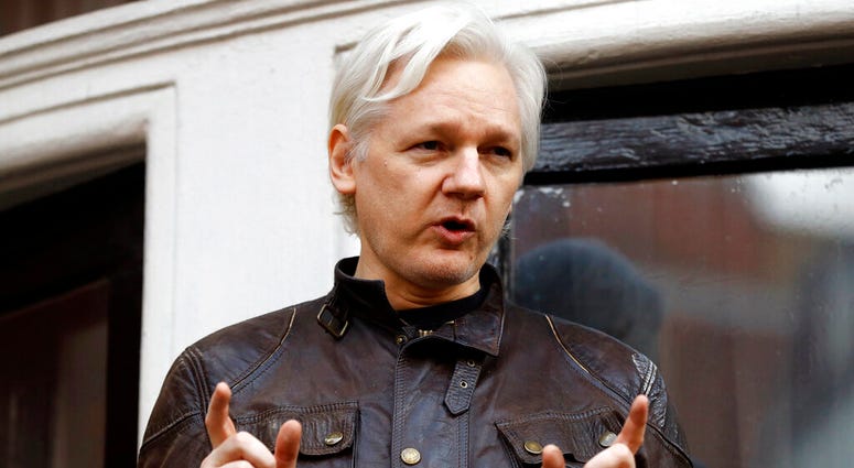 FILE - In this May 19, 2017 file photo, WikiLeaks founder Julian Assange gestures to supporters outside the Ecuadorian embassy in London, where he has been in self imposed exile since 2012. (AP Photo/Frank Augstein, File)