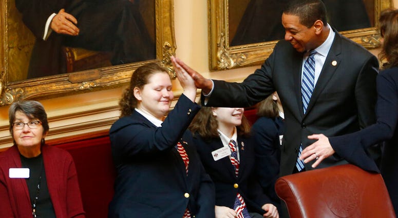 Virginia Lt. Gov. Justin Fairfax, right, gives a high five to a page as he prepares for the start of the Senate session at the Capitol in Richmond, Va., Friday, Feb. 8, 2019. (AP Photo/Steve Helber)